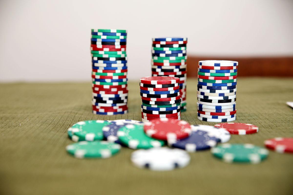 Tumpukan chip poker warna-warni di atas meja